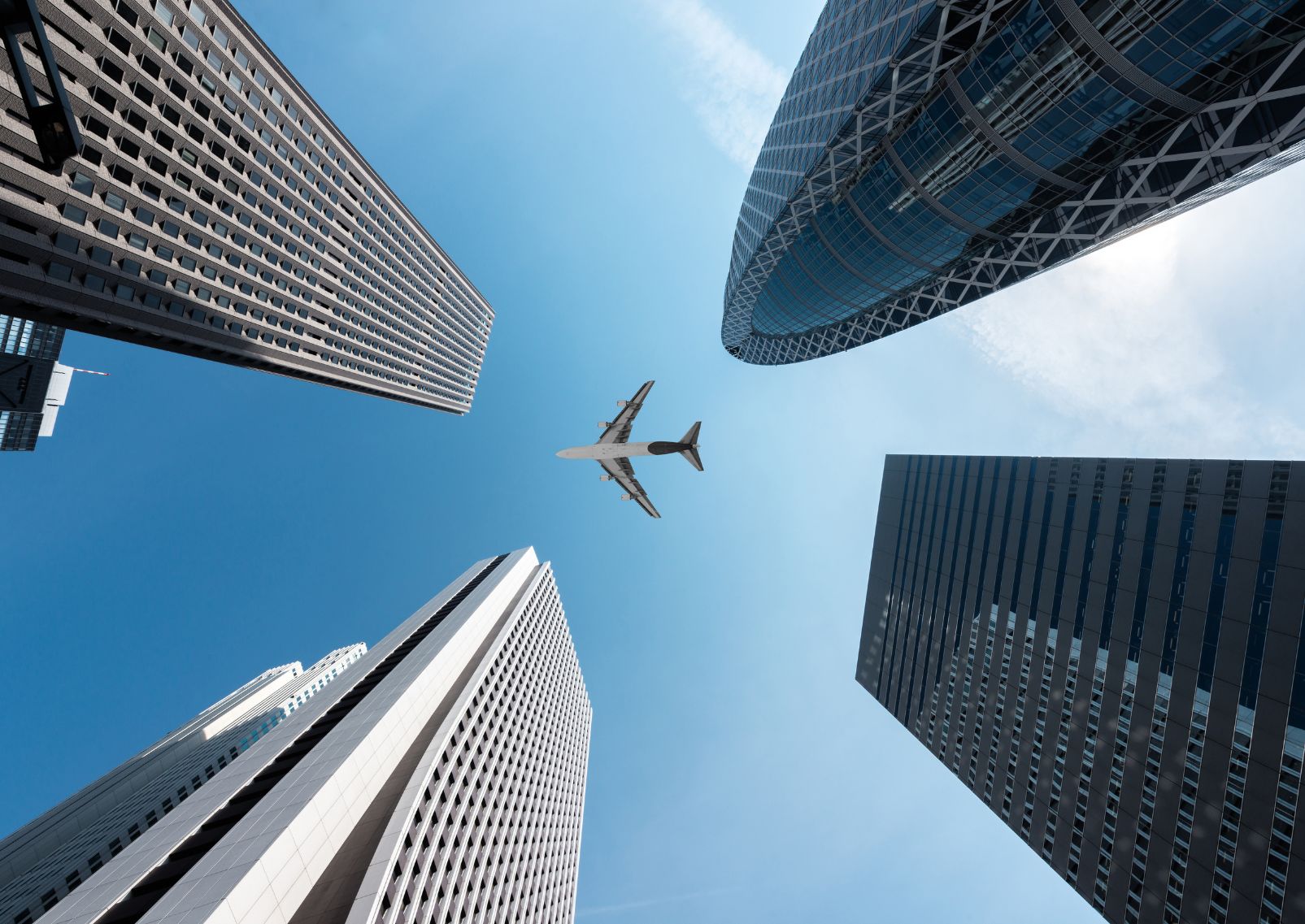  Een vliegtuig is zichtbaar in de lucht tussen de wolkenkrabbers in Tokyo, Japan.