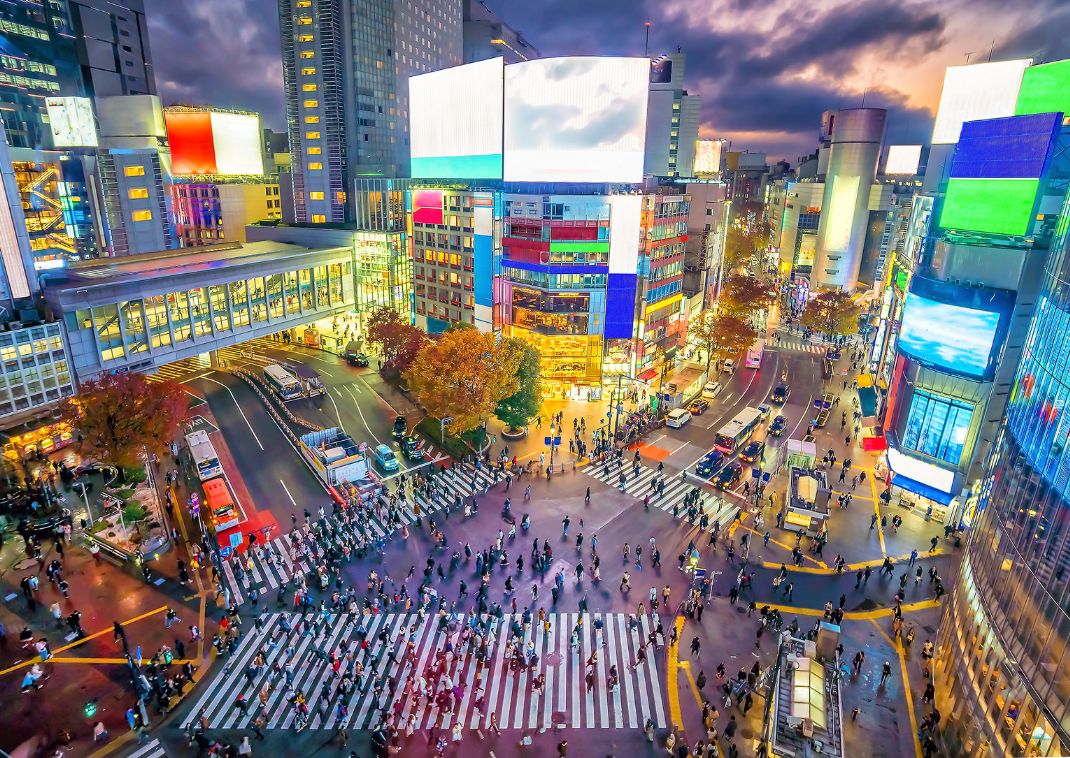 Shibuya Crossing bij schemering in Tokyo, Japan.