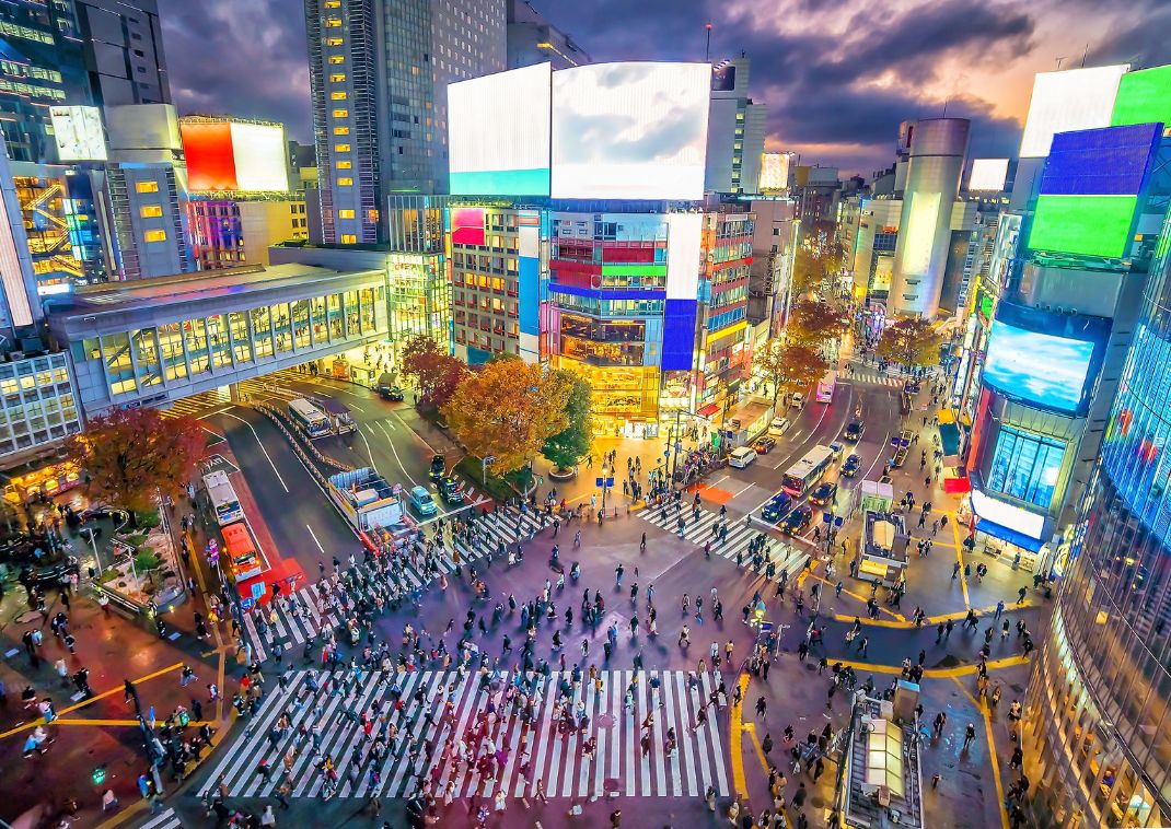 Shibuya Crossing bij schemering in Tokyo, Japan.