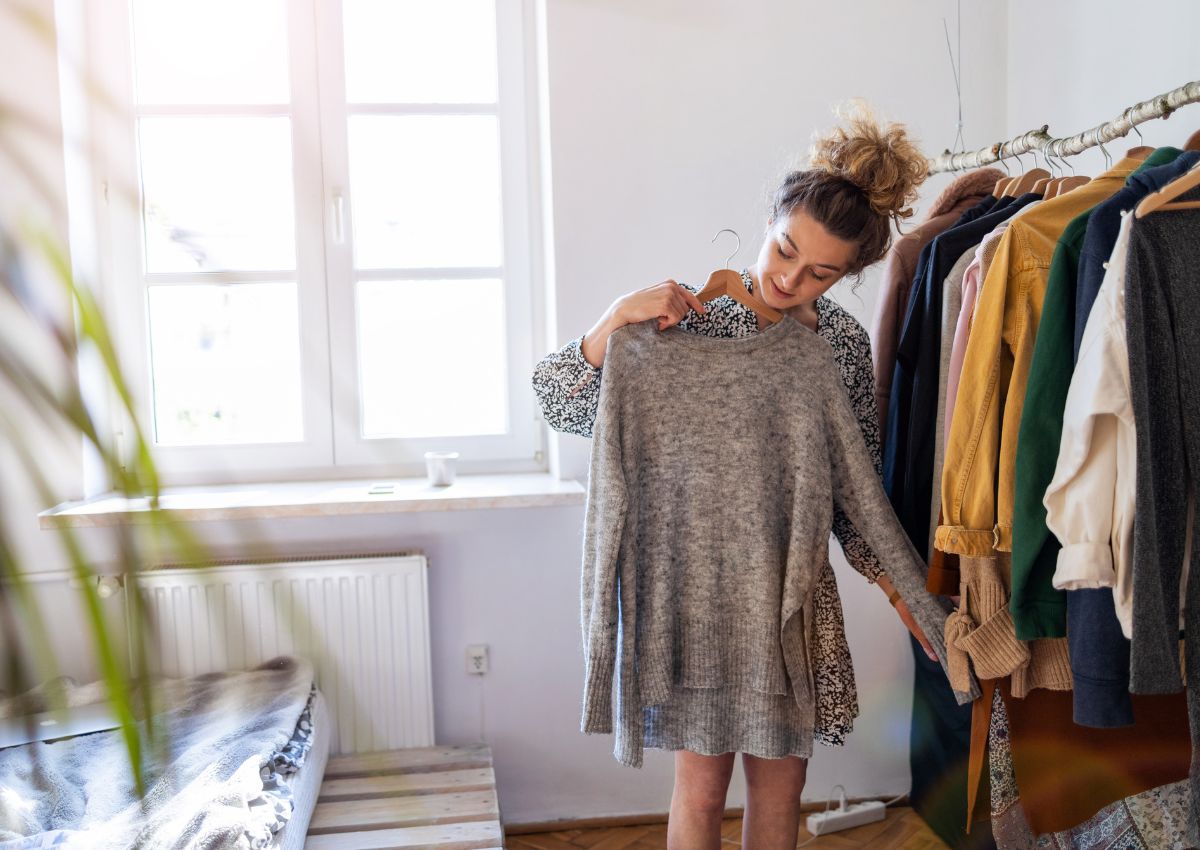 Vrouw die thuis kleding kiest voordat ze haar koffer inpakt voor een reis naar Japan