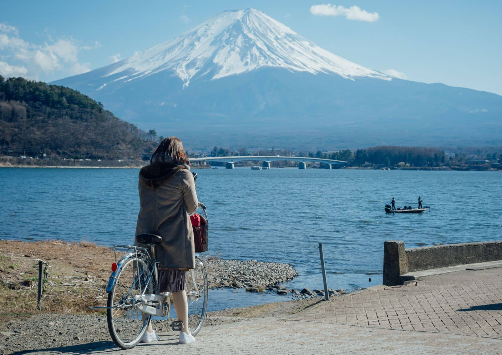 Fietser bewondert het uitzicht op de berg Fuji bij het Kawaguchi-meer in Japan.