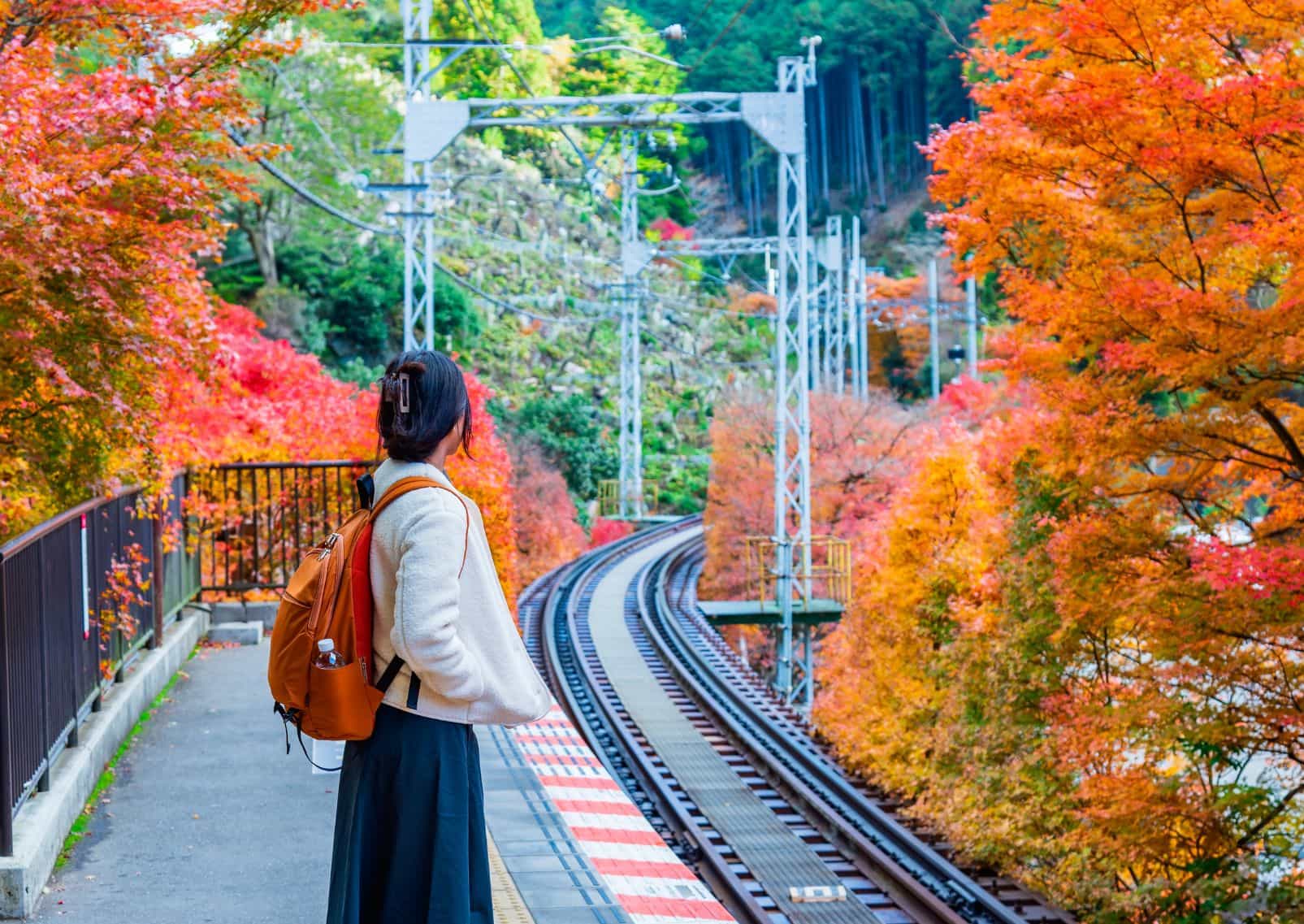 Meisje wacht op trein in Japen tijdens de herfst