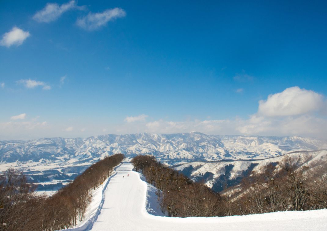 Besneeuwde skipiste bij Nozawa Onsen met berglandschap 
