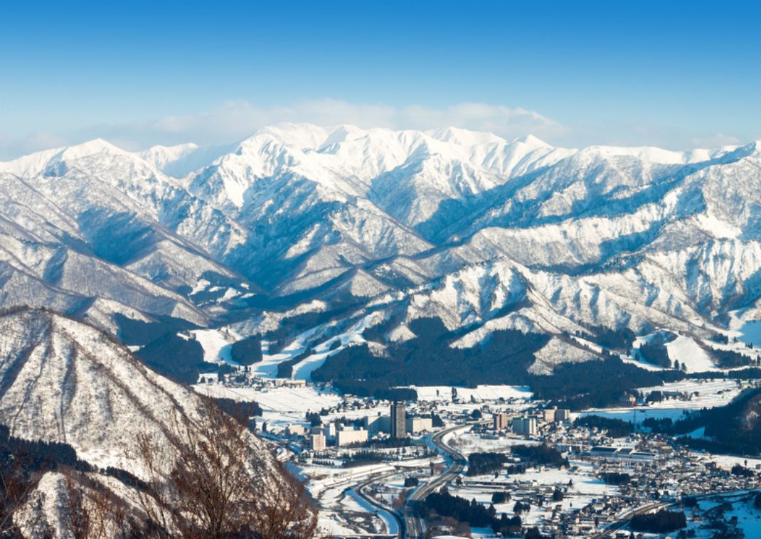 Besneeuwde skipiste bij Nozawa Onsen met berglandschap