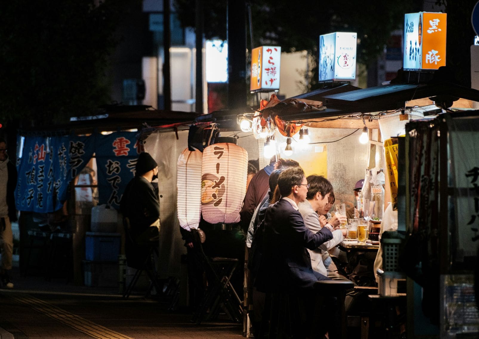 Groep mensen aan de eetkraampjes van Fukuoka, ook wel yatai genoemd
