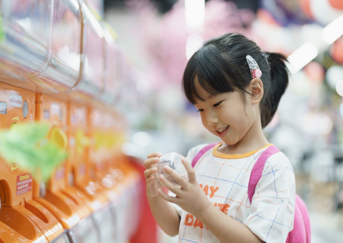 Meisje voor een Japanse gacha-automaat