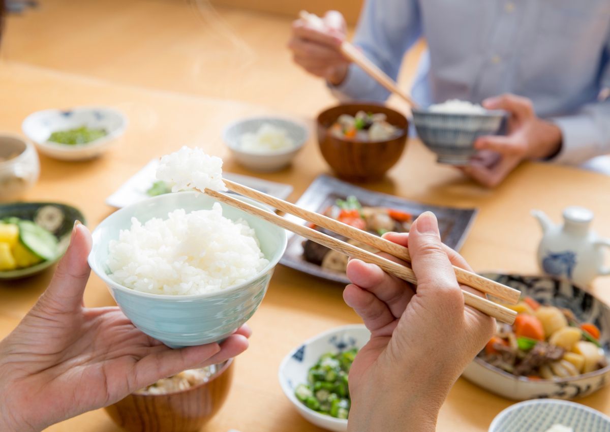 Japanse persoon die een kom gestoomde rijst vasthoudt