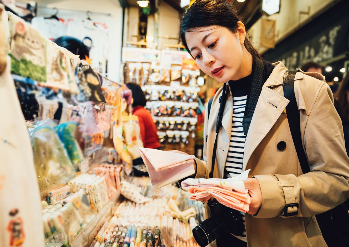 Vrouw die een handdoekje uitkiest in een souvenirwinkel