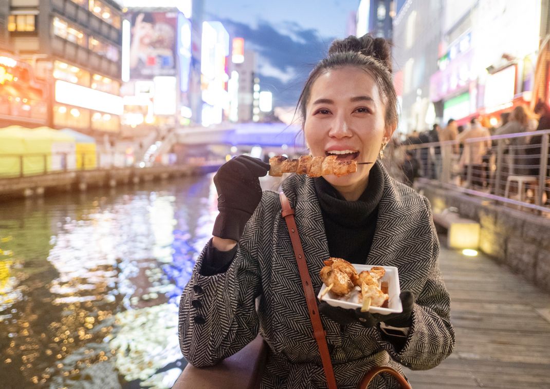 Japanse vrouw geniet van authentieke streetfood in Osaka