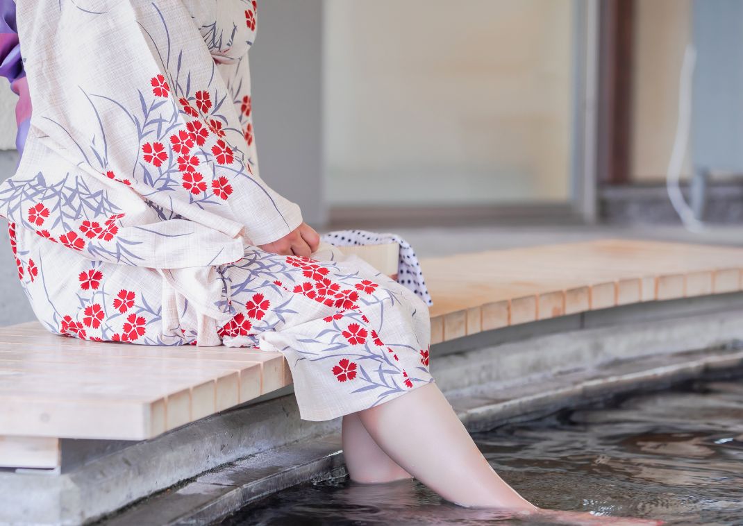 Dame in Japanse yukata bij een voetbad, Japan