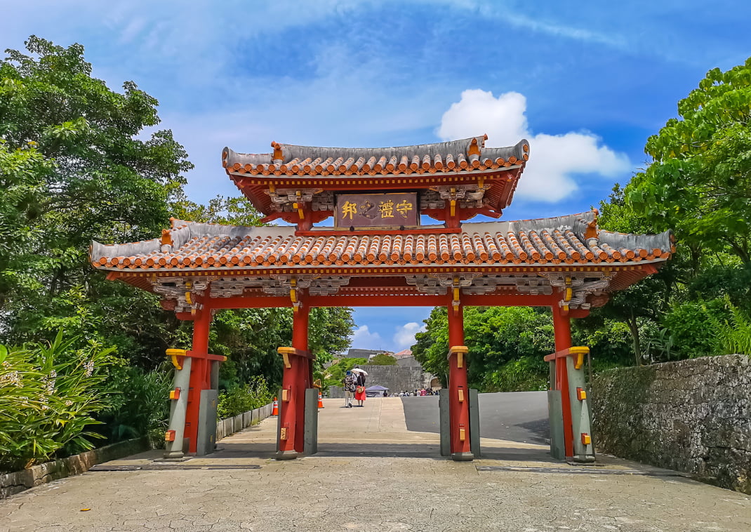  De rode Shureimon poort van het Shuri-kasteel in Okinawa, Japan, met een blauwe lucht.