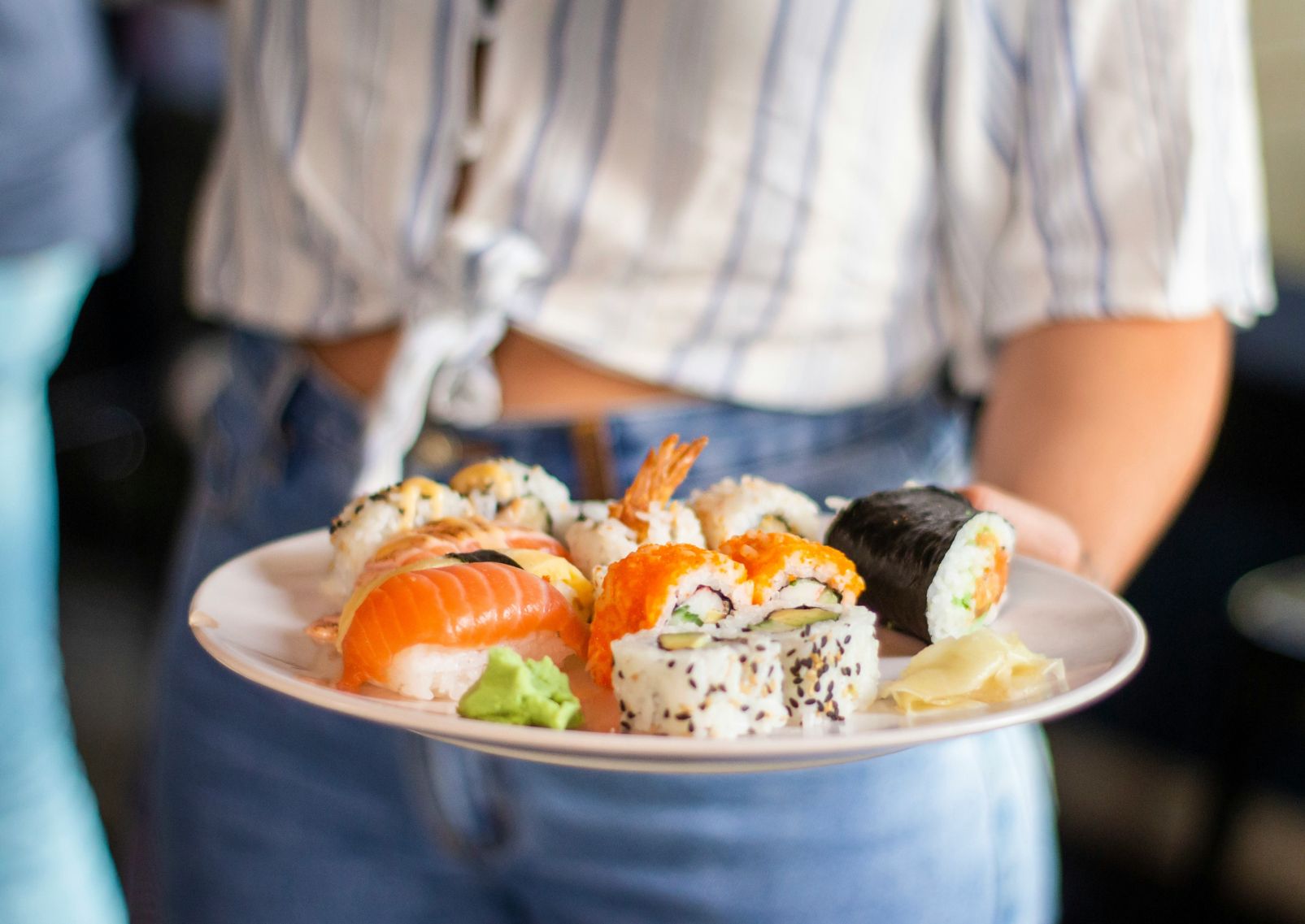Een vrouw serveert verse sushi aan tafel in Japan