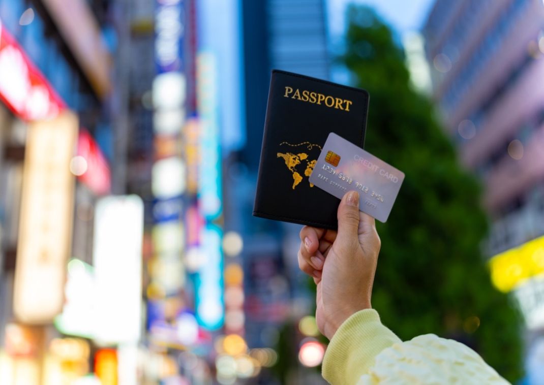 Hand van een vrouw die een paspoort en creditcard vasthoudt in Tokyo.