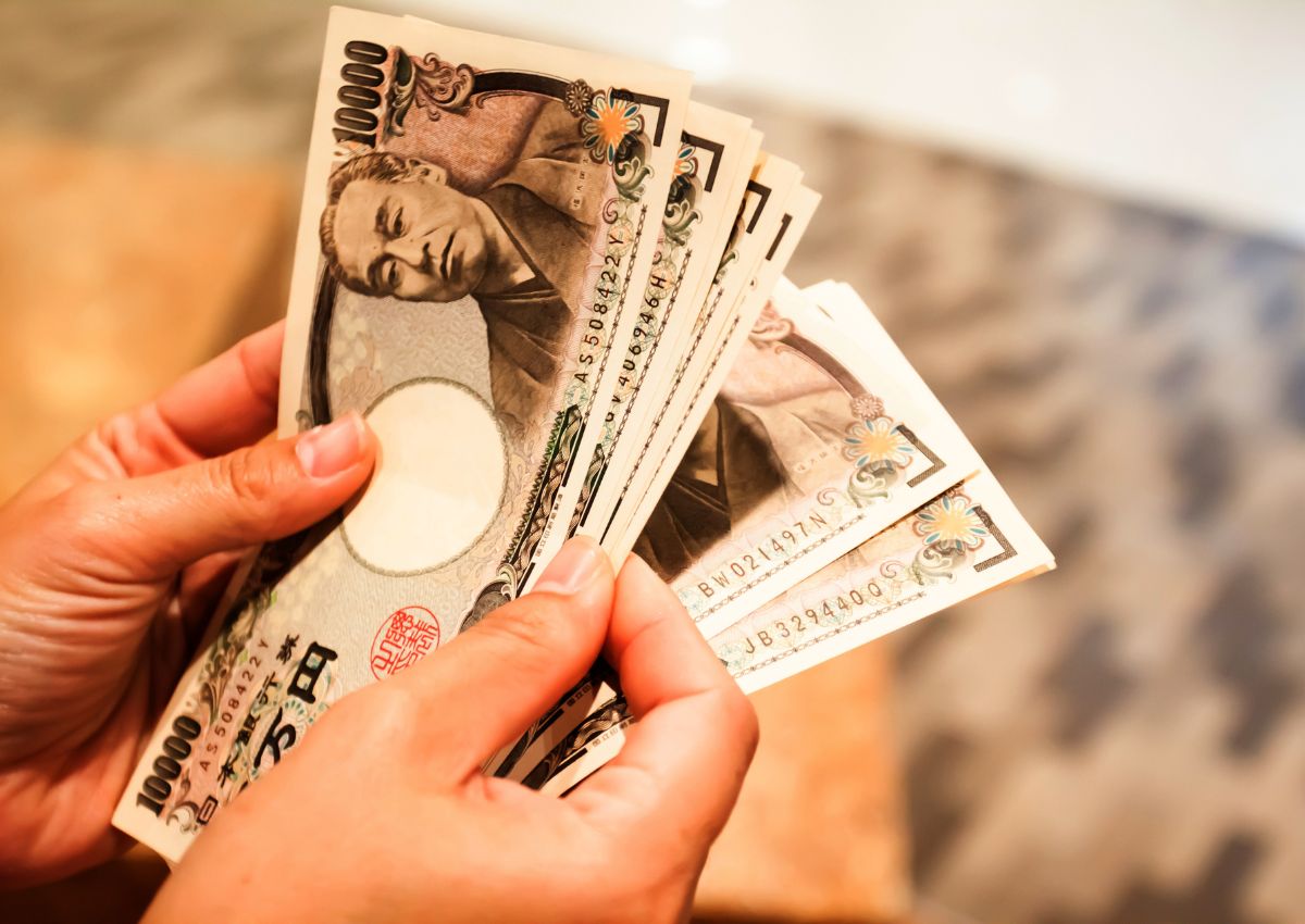Persoon die Japanse yenbiljetten telt