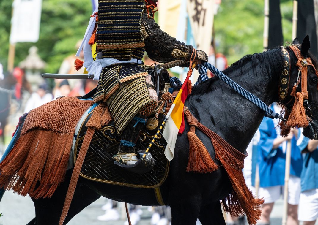 Samurai in harnas rijdt op een paard tijdens Jidai Matsuri in Kyoto.