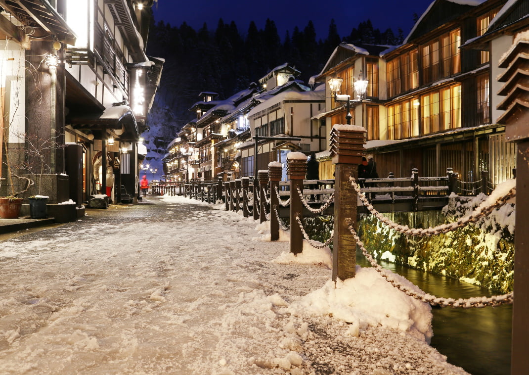 Oude Japanse hotels bij nacht in de sneeuw in Ginzan Onsen.