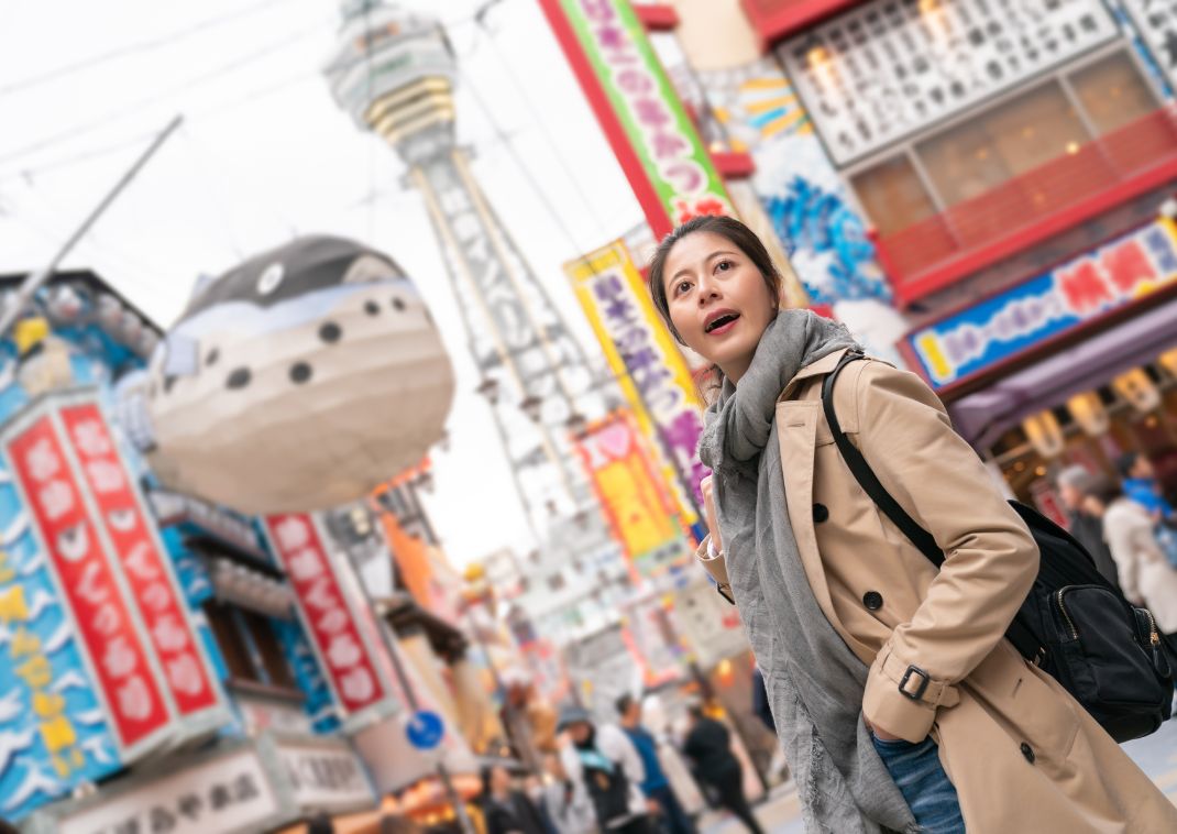 Jonge Aziatische vrouw verkent de wijk Shinsekai in Osaka.