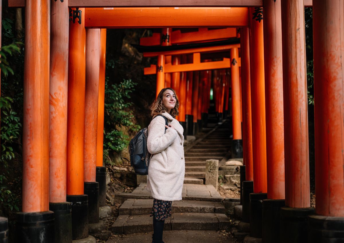 Vrouw bij de torii-poorten van het Fushimi Inari-schrijn in Kyoto