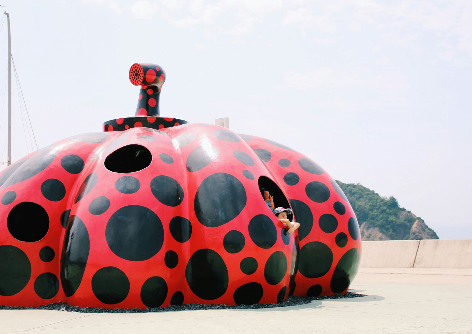  Het beeldhouwwerk <em>Rode Pompoen</em> van Yayoi Kusama op het eiland Naoshima, Japan.