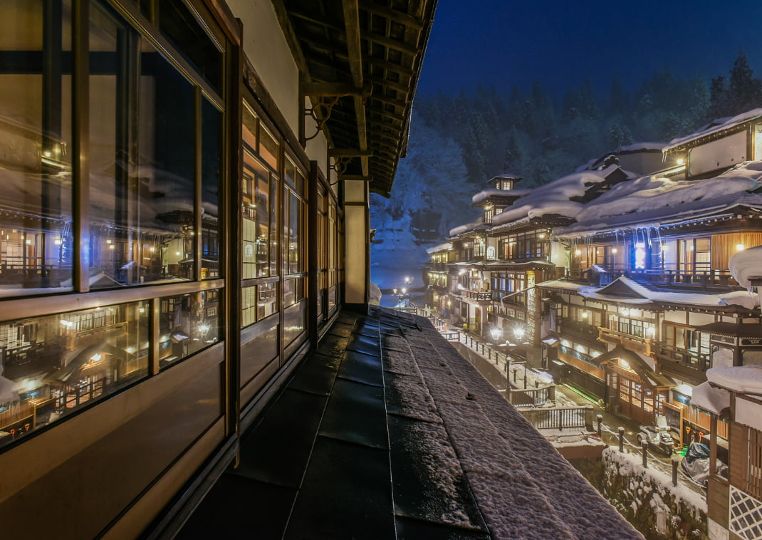 Nachtzicht op de besneeuwde oude stad van de beroemde hot spring-bestemming Ginzan Onsen, Obanazawa, Yamagata, Japan.