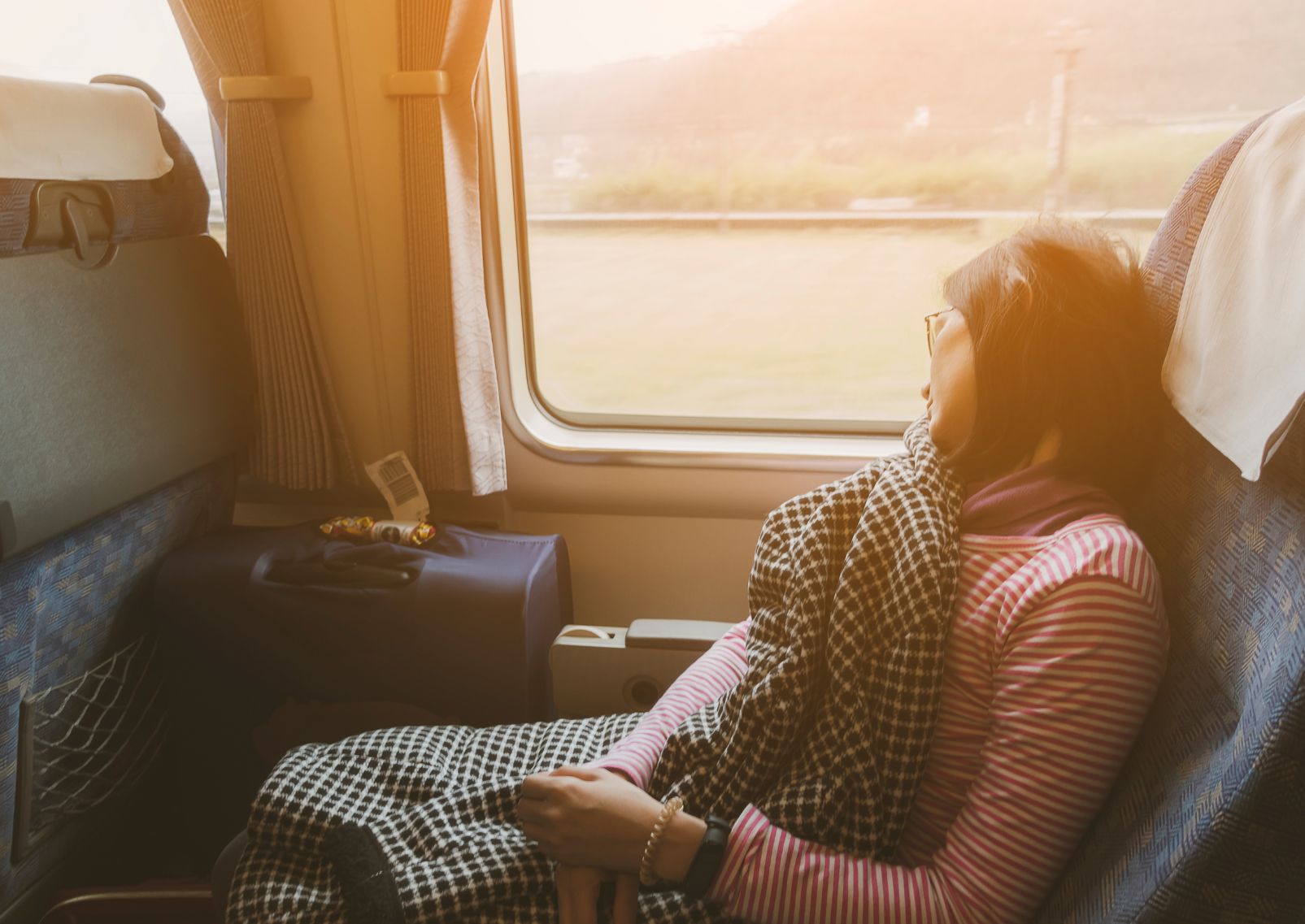 Vrouwelijke reiziger slaapt bij het raam in een trein in Japan.