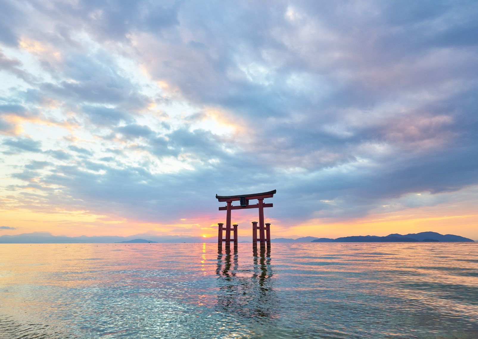 Zonsondergang bij de beroemde rode torii-poort in het water van het Biwameer, prefectuur Shiga, Japan.