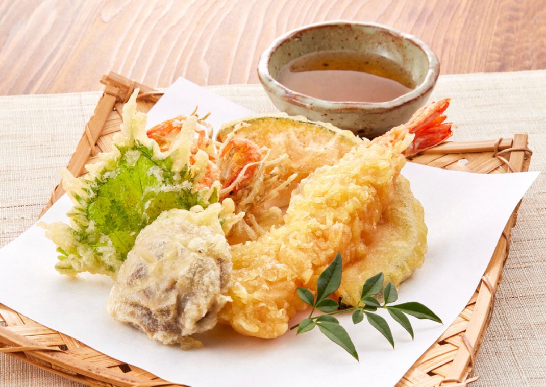 Een bord tempura: krokant gefrituurde groenten en garnalen