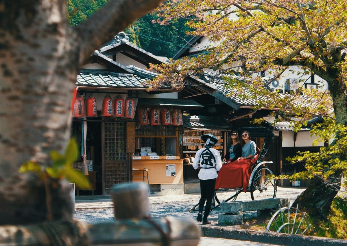 Twee toeristen in een Japanse riksja in Kyoto