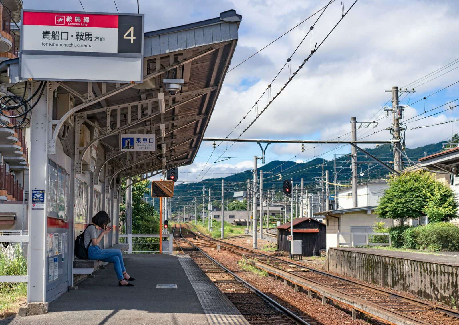 Meisje op haar telefoon op het treinstation in Kyoto, Japan
