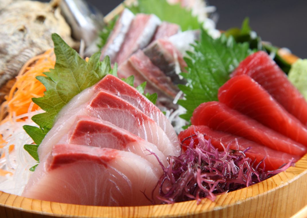 Verse Japanse sashimi geserveerd op een houten schaal.