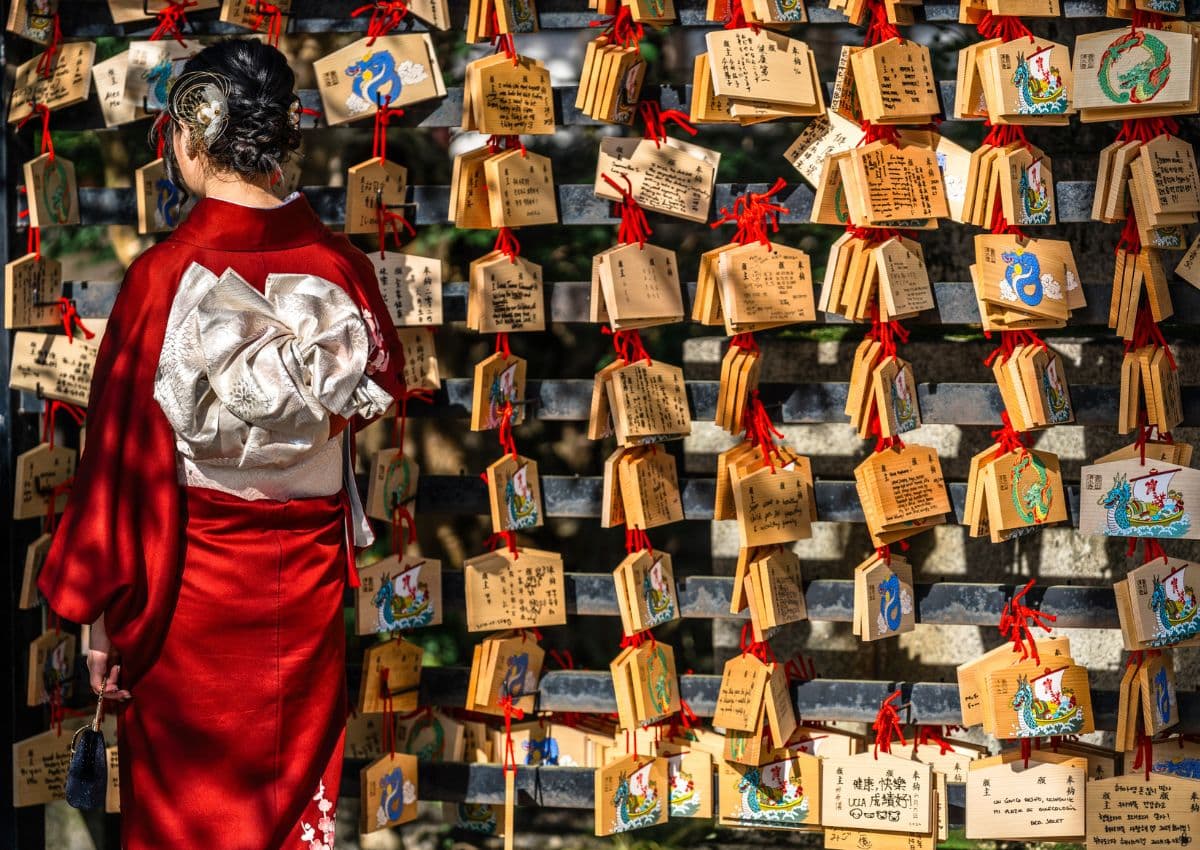 Jonge vrouw in kimono bij een Japans heiligdom