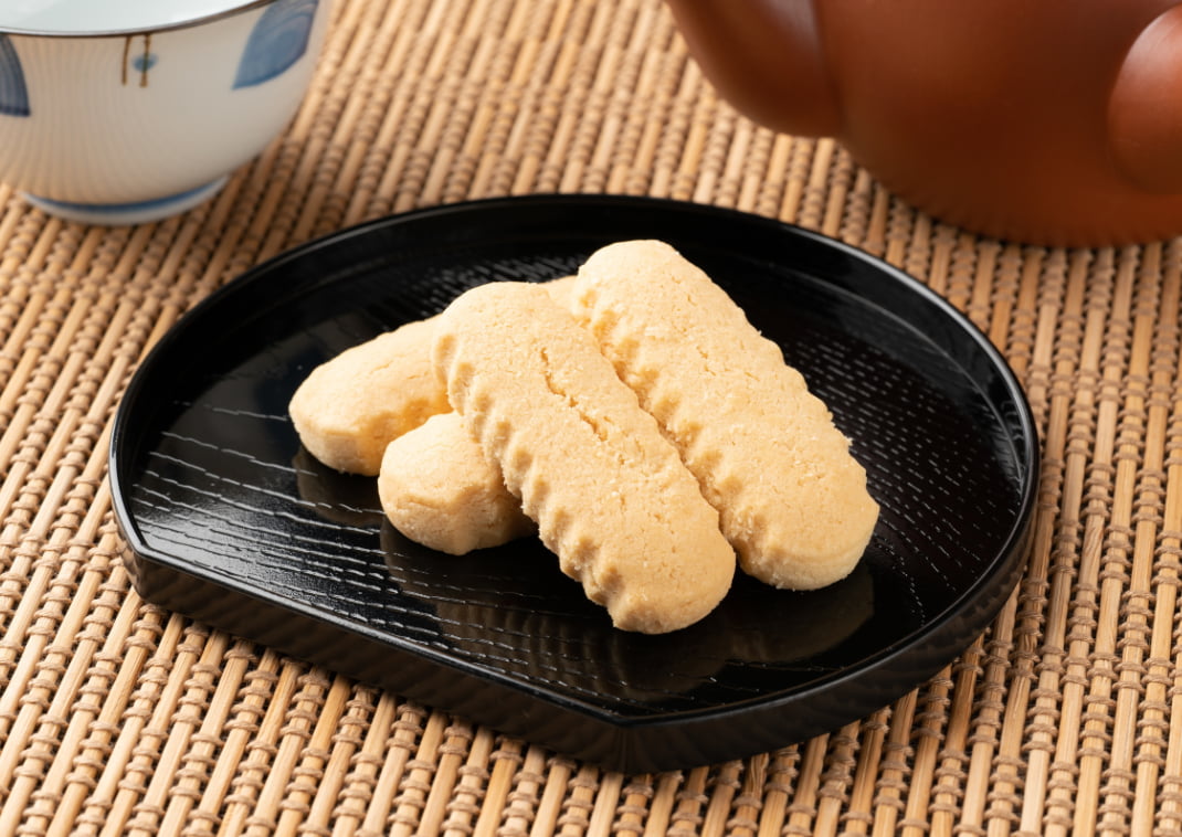 4 chinsuko koekjes op een zwart bord, een snack uit Okinawa, Japan.