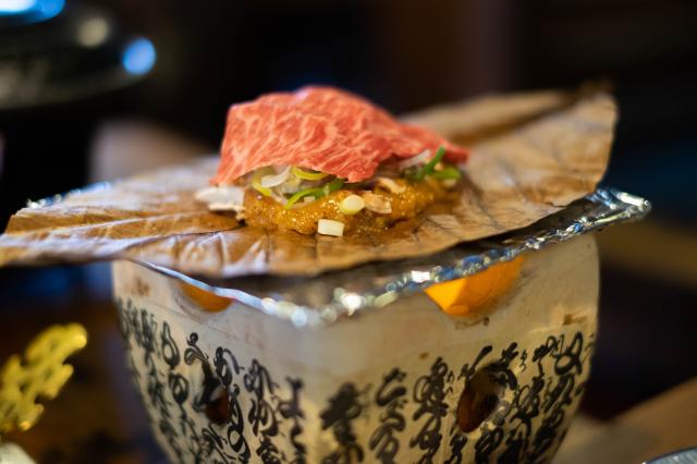 Op houtskool geroosterd Hida rundvlees op een oba-blad met miso en groenten