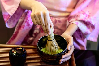 Dame in kimono die Japanse groene thee maakt