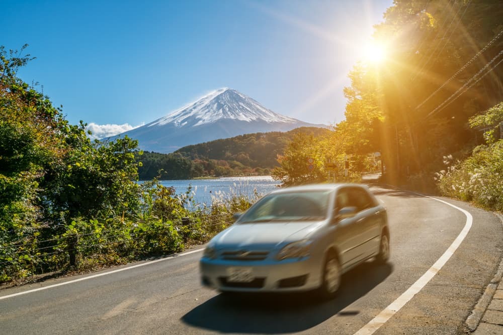 Auto die nabij Mt Fuji in Japan drijft met bewegingsonscherpte die snelle beweging op een snelwegweg bij Meer Kawaguchiko toont