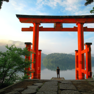 Toerist bij de rode torii poort van Hakone Shrine, gelegen aan het Ashi meer, Japan