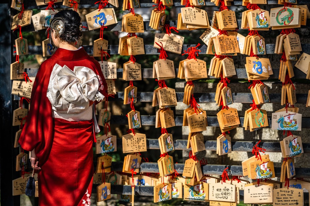 Japanse vrouw leest gebedsprentjes op een houten bord in de Kiyomizu-dera tempel in Kyoto