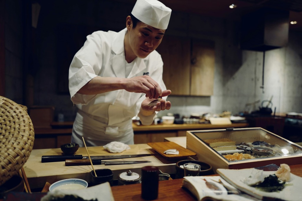 Japanse chef-kok maakt sashimi voor de bar van een Japans sushirestaurant