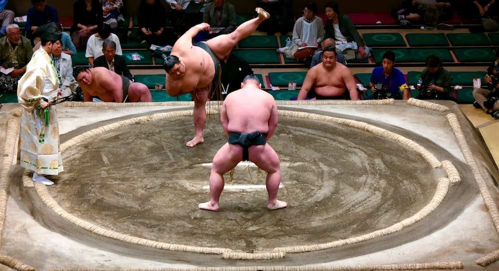 Japanse sumoworstelaars bereiden zich voor op een wedstrijd in de ring, met traditionele mawashi aan