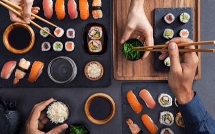 Assortiment sushi waaronder nigiri, sashimi en rollen die worden gedeeld en gegeten met stokjes