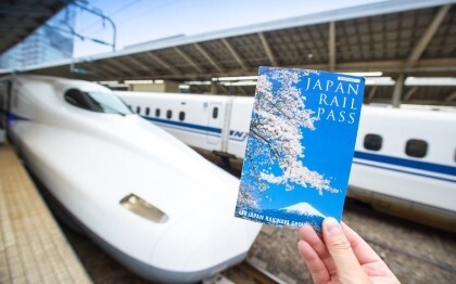 Hand met een Japan Rail Pass ticket voor een Shinkansen op Tokio Station
