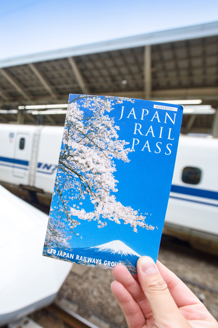 Hand met een Japan Rail Pass ticket voor een Shinkansen op Tokio Station